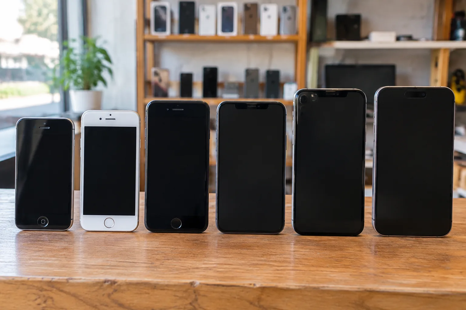 Plusieurs iPhone de générations différentes alignés sur un établi pour comparaison