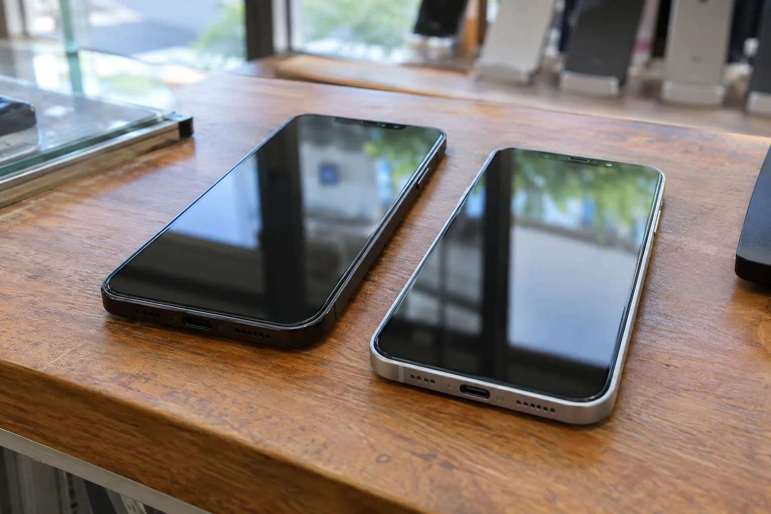 Smartphone Samsung Galaxy et iPhone posés côte à côte sur un comptoir de boutique